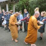 Children from Kapiti College offer alms.