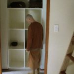 Venerable Kondanyo inspecting the new monks lockers in the Bhikkhu vihara. The stairs to the loft over the common room to right.