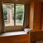 Just inside the entrance of Raja kuti - bed right window seat storage lockers kitchen right.