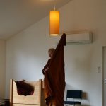 10:25 am - lunch is an imminent possibility. Venerable Phasuko puts on his robe in preparation.