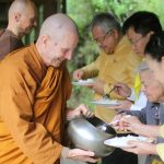 Bee: Embassy staff and friends offer pindapat to the Sangha.