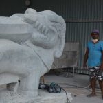 One of the workers next to a large makara (guardians - half terrestrial animal half aquatic). Safety gear was minimal with steel toe-cap boots optional.