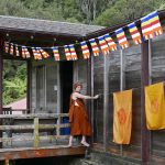 An intrepid Ajahn Hasapannyo setting flags in front of the cloister.