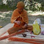 Luang Por making umbrellas to give away at the forthcoming funeral of Luang Por Plian.
