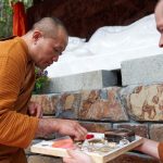 Stupa dedication: ajahn Dta adding relics at the base of the buddha rupa.