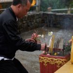 Chang braves the rain to make offerings. Sadhu!