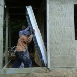 Anagarika McBain and Bruce wrestling the door into the new kuti in the lay residents zone.