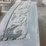 The entry step. The motif echoes the foliage band of the moonstone.