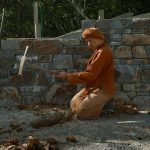 Ajahn Dta in the stupa forecourt setting a few level points for the digger. The clay is almost as hard as the rock.