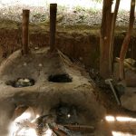 An earthen oven used for both the kettle and for the (very) large bowl used for dye-washing robes. Note the bamboo chimneys.