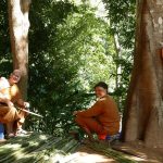 Aj Kusalo with the abbot learning how to strip palm fronds to make the material for broom making.