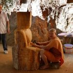 One of the monks working on carving a buddha image.