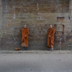 Two monks under a bridge.