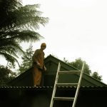 Venerable Issaro on the workshop roof fixing the light.
