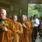 Ajahn Sucitto leads the sangha and the laity in a circumambulation of the sala.