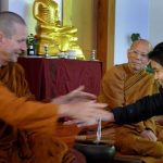 Ajahn Kusalo gives a blessed thread to Eve.