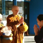 Venerables Aruno and Kusalacitto chant a blessing while on pindapat in Stokes Valley.