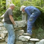 Simon and Gavin lifting a major stone onto the top of the new stairway wall. Built to last.