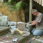 Simon carefully placing a corner stone at the bottom of the stairs.