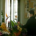 Nuk gives concentrated attention to create beautiful flower arrangements for Kathina.