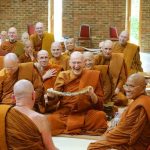 Ajahn Sumedho offering Ajahn Khemadhammo a robe.