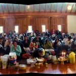 A four-shot pano of the Songkran gathering. 250 people happily packed into the hall. Lovely.
