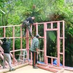 John fixing the finished walls together on the lower kuti with Craig and Justin lending a steady hand.