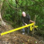 John our kuti builder doing a quick site level check to order the foundation timbers.