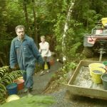 Peter and Clare carrying buckets along the new kuti track.