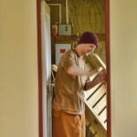 Venerable Hiriko applying finishing touches to the door of the renovated triplex.