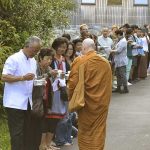 Ajahn Ariyasilo receiving rice at the end of the New Years day pindapat.