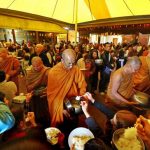 The Sangha goes on rice pindapat around the cloister on Kathina day 2012. The light of the marquee casts a soft ocher light.