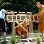Teamwork ensures that the commemorative plaques are installed upright and level.