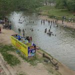 Ritual bathing in the river. Katragama temple in the background.