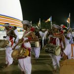 Traditional drummers circumambulate the stupa.