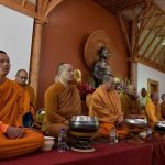 The Sangha has gathered in the Dhamma Hall and wait patiently for everyone to settle.