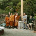 All gathered to lower the pole in the west corner of the stupa enclosure. Many strings attached.