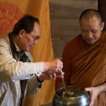 Ajahn Dta receives a food offering.