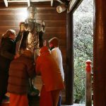 Monks and men move the Buddha to a higher place.