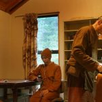 Ajahn Sambodhi works on the kathina robe borders. Ajahn Sudhiro works on - his phone :)