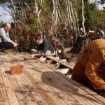Shaun carefully measures the spacing of the deck boards.