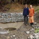Venerable Buddhisaro and Sam putting the last touches to the landslide sump apron as part of the vihara concrete pour.