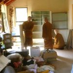 Stores from what is now the new office have moved to the back of the dhamma hall. To make room the monks sewing room left the dhamma hall and is here being reassembled in the upper house.