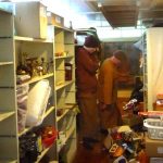 An empty shelf stands empty while Ajahn Ariyasilo and Venerable Hiriko ponder the fate of remaining remains in the Dhamma sala store.