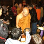 Ajahn Nantawat amidst the happy throng filling the cloister to offer rice pindapat.