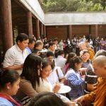 The Sangha going pindapat around the cloister with the community lined up three or more deep on all four sides.