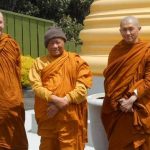 Ajahn Kusalo Chao Khun Maha Suthep and venerable Thitavijjo standing in front of the stupa at the Island Bay Monastery.