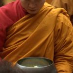 Receiving alms with focus and gratitude.